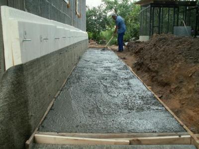 заливаем правильно приготовленный бетон и выравниваем его с учетом необходимого уклона отмостки
